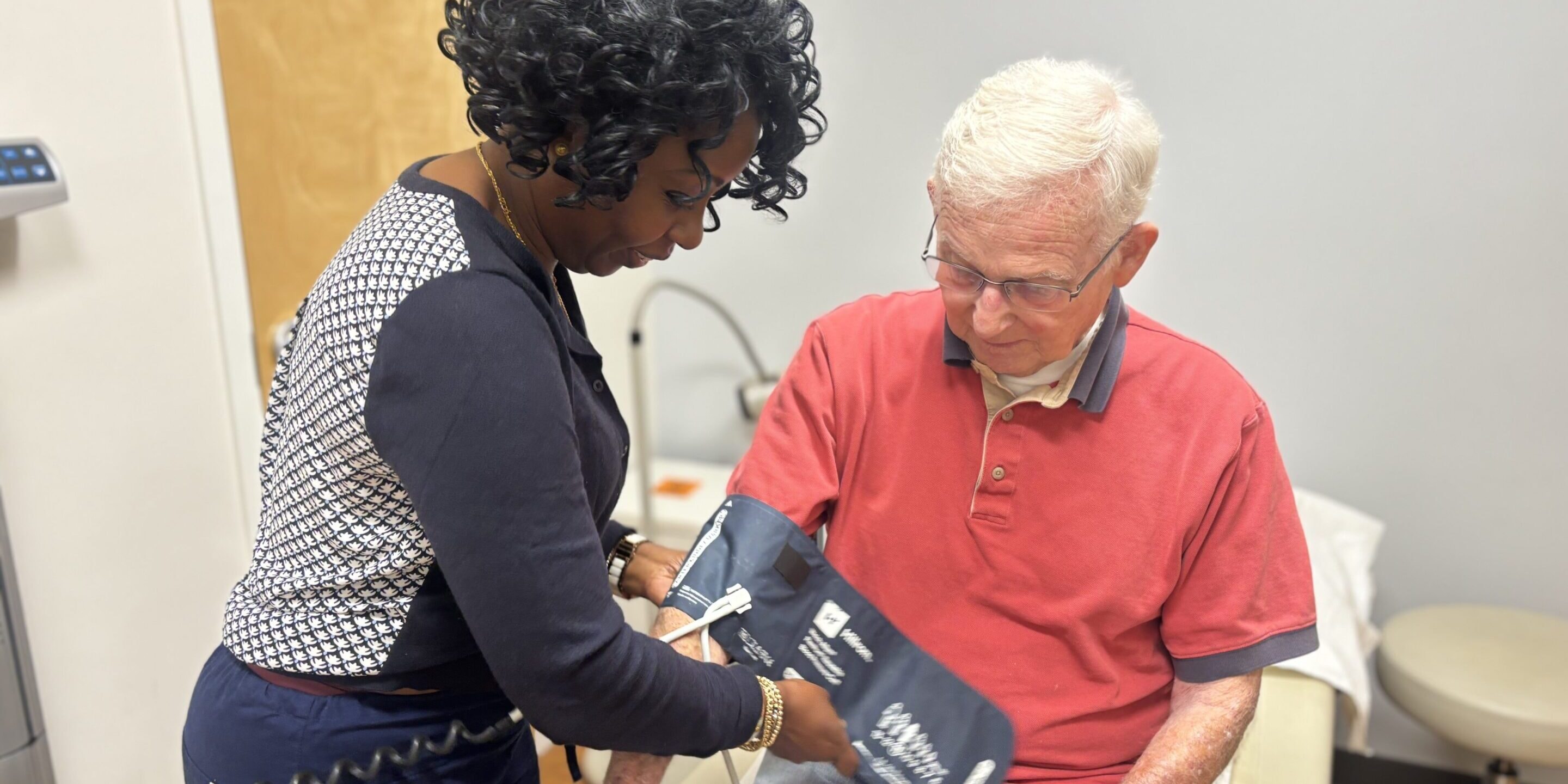 Healthcare professional taking an elderly man's blood pressure